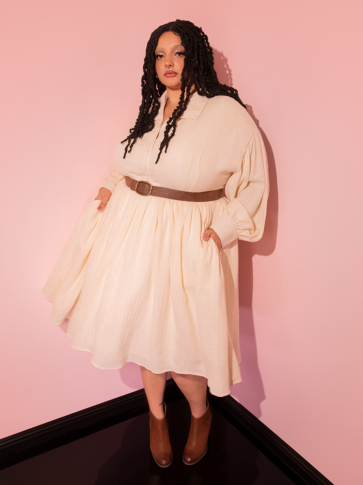 Elevate your style with the all new Cream Fantasy Shirtdress boasting a Faux Leather Belt, as showcased by our retro model, sourced from Vixen Clothing's vintage collection.
