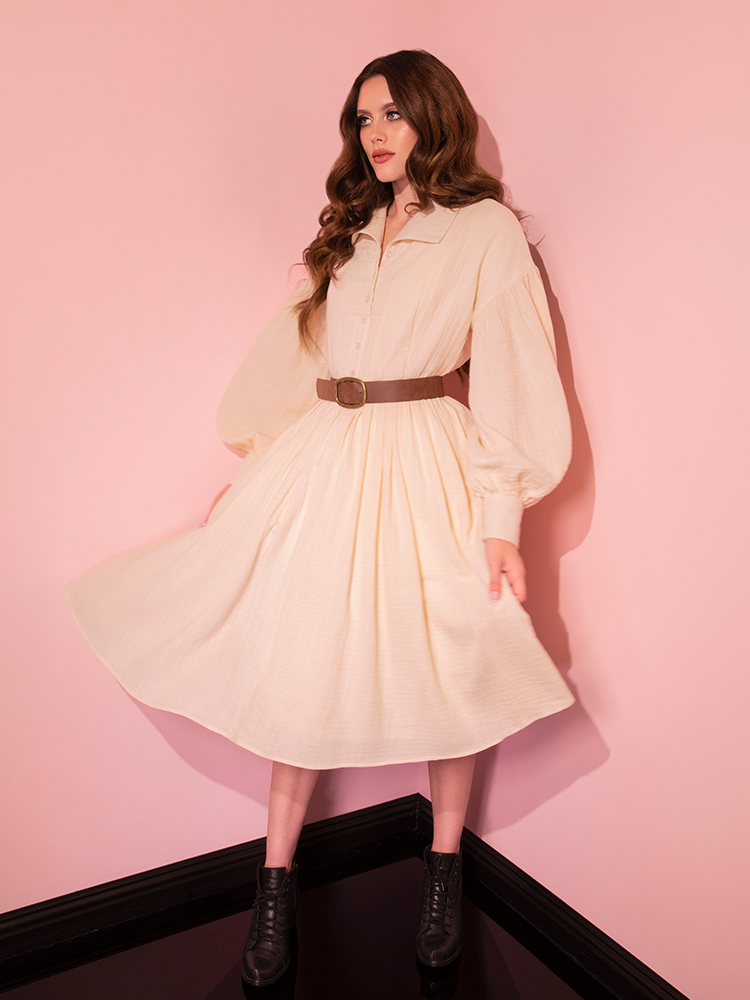 Experience timeless allure as our gorgeous model wears the Fantasy Shirtdress in Cream, accentuated by a Faux Leather Belt—a masterpiece from Vixen Clothing's vintage collection.