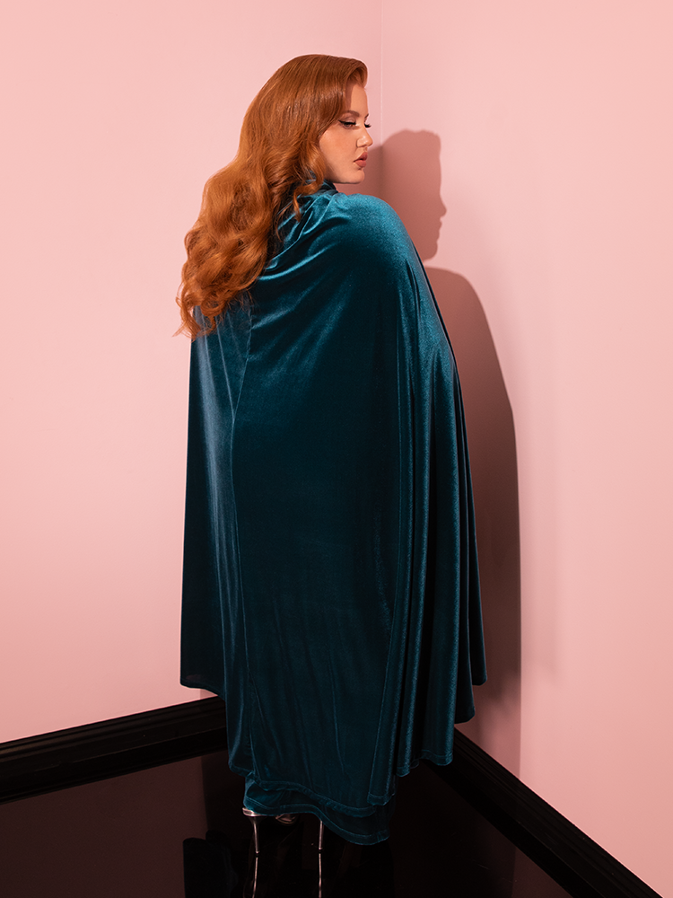 Vintage glamour comes alive as models strike various poses, highlighting the beauty of the Golden Era Cape in Teal Velvet from Vixen Clothing.