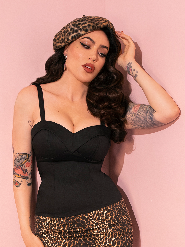Effortlessly chic, Micheline Pitt strikes poses in the retro-inspired Maneater Top in Black from Vixen Clothing, epitomizing retro glamour.