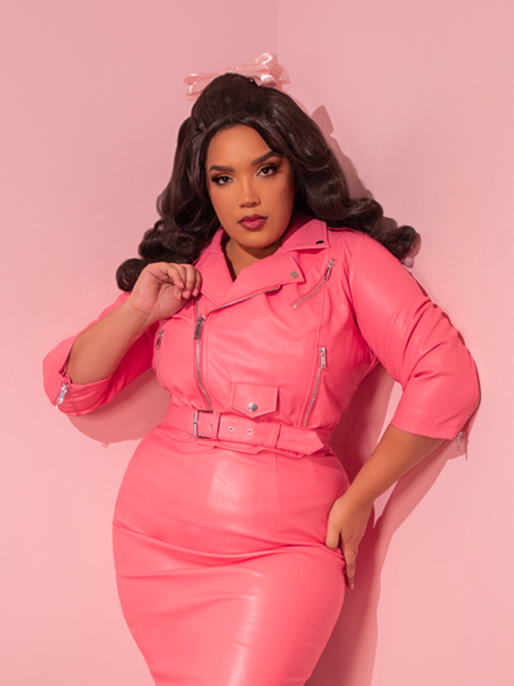 Marvel at the sight of the stunning retro diva, elegantly showcasing the brand new Bad Girl 3/4 Sleeve Cropped Motorcycle Jacket in Flamingo Pink Vegan Leather, a vintage-inspired gem from the renowned fashion house, Vixen Clothing.