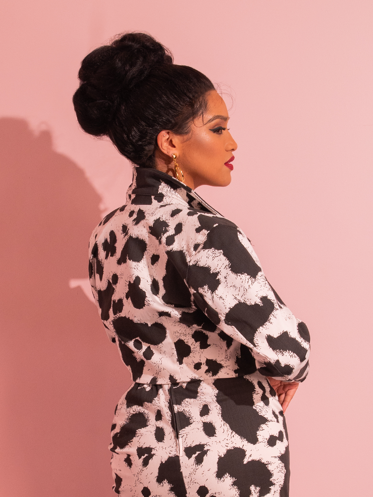 With an irresistible retro vibe, a beautiful female model mesmerizes as she models the Rebel Cropped Jacket in Cow Print, a sartorial gem hailing from the iconic Vixen Clothing brand.