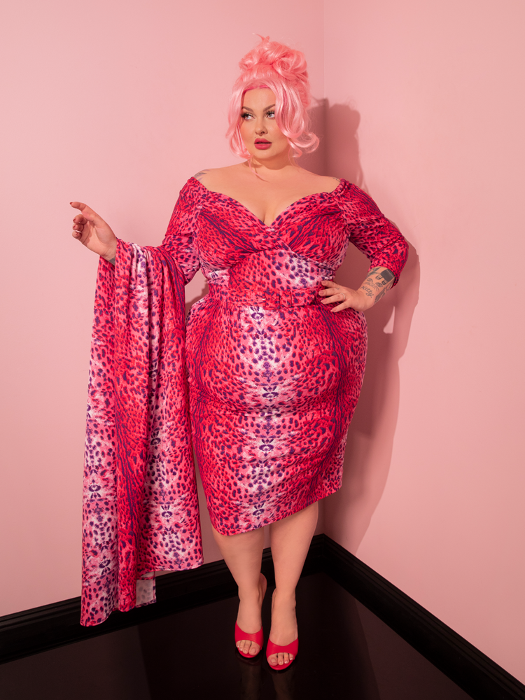 Transport yourself to the golden era of fashion as a stunning lady showcases the Pink Leopard Print Starlet Wiggle Dress and Scarf, curated by the vintage-inspired brand Vixen Clothing.