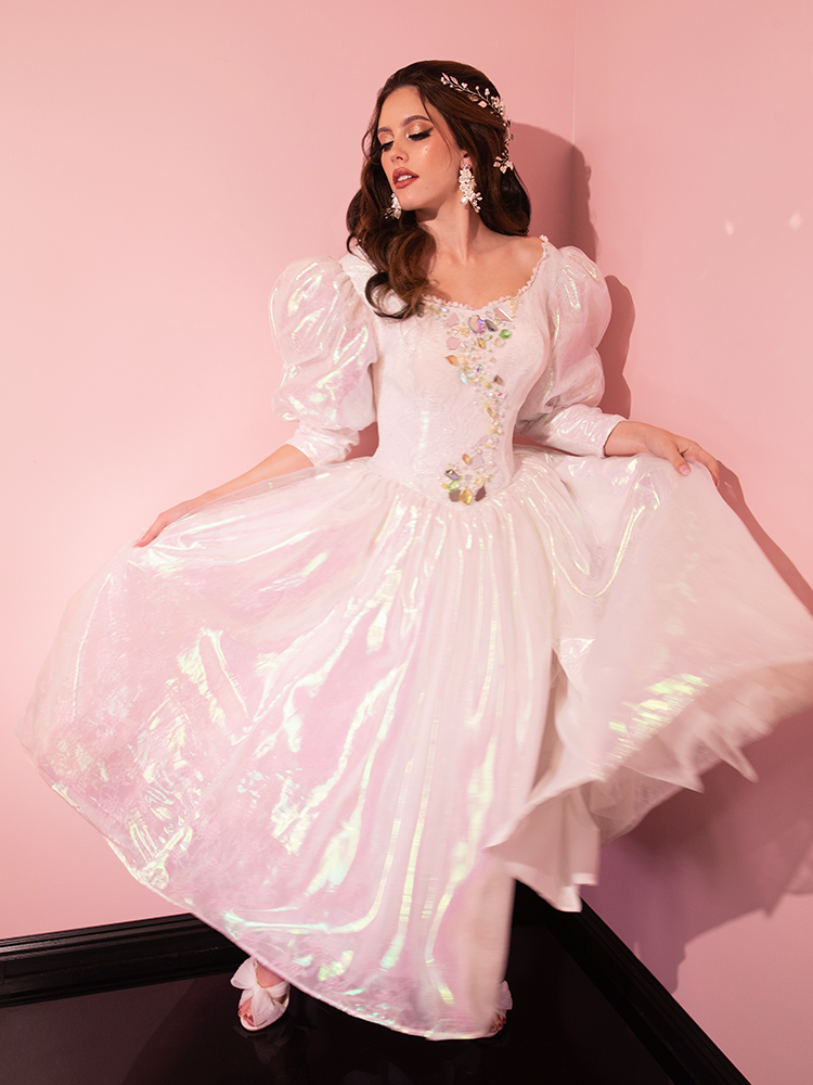 Oh, the sartorial splendor of a glamorous lady sporting the very limited edition Pearlescent White LABYRINTH™ Sarah Goblin Ball Gown, a bewitching find from Vixen Clothing, the vintage curator extraordinaire.