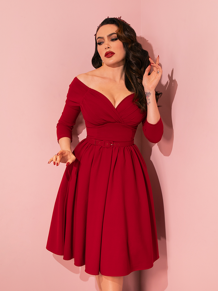 Micheline Pitt effortlessly captures attention with striking poses in Vixen Clothing's Wrap Top in Red Velvet, showcasing the allure of this vintage-inspired retro dress.