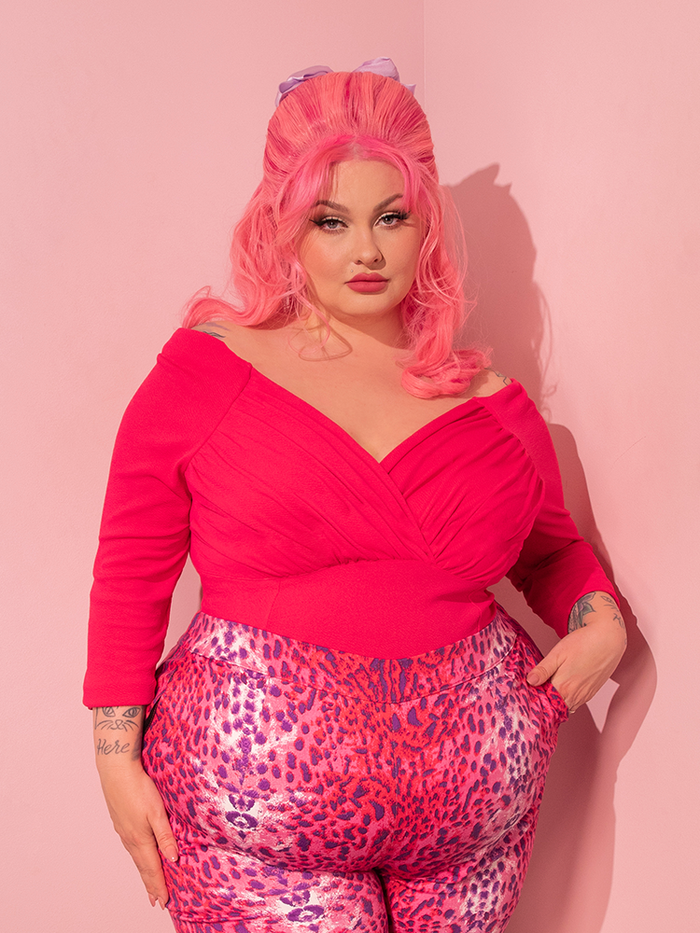The Starlet Top in Hot Pink, a mesmerizing piece from the renowned retro clothing brand Vixen Clothing, enhances the female model's stunning appearance.