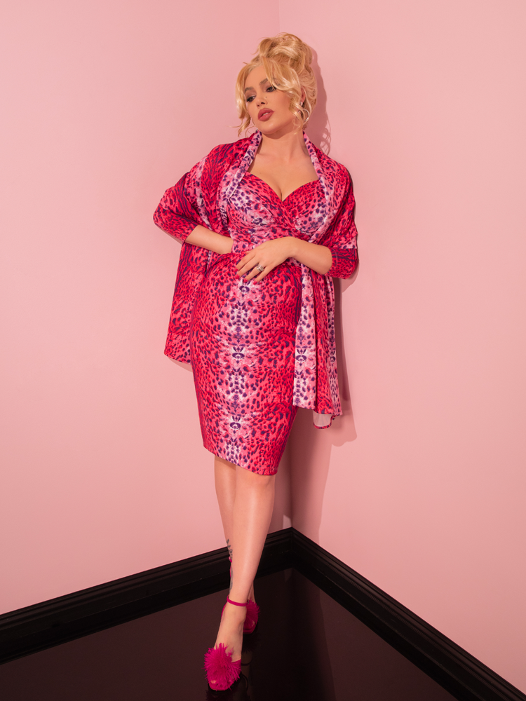 Marvel at the nostalgic charm embodied by a gorgeous lady, effortlessly donning the Pink Leopard Print Starlet Wiggle Dress and Scarf from Vixen Clothing's retro-inspired line.
