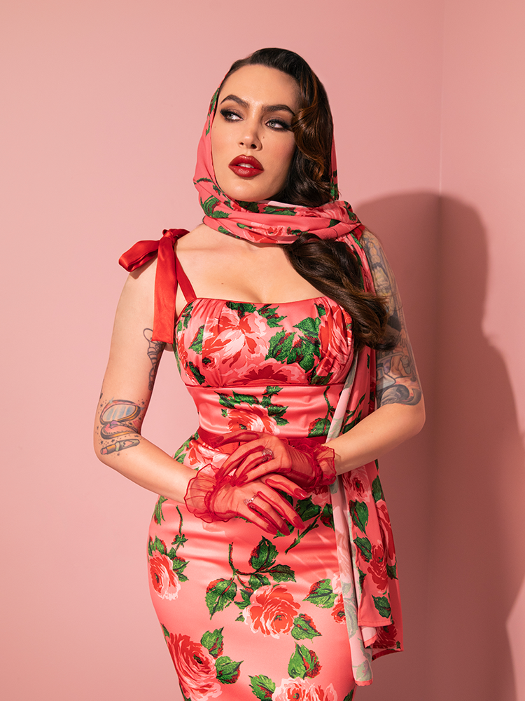 Behold the allure of the 1950s Satin Wiggle Sundress and Scarf in Pink Vintage Roses, flawlessly presented by the retro fashion enthusiast from Vixen Clothing.