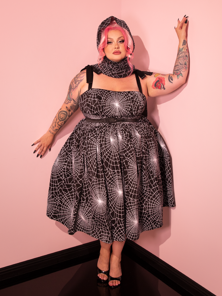 Explore the charm of retro aesthetics with Vixen Clothing's fresh addition, the 1950s Swing Sundress and Scarf in Black and White Spider Web Print, offering a loving nod to vintage style with a touch of spookiness.