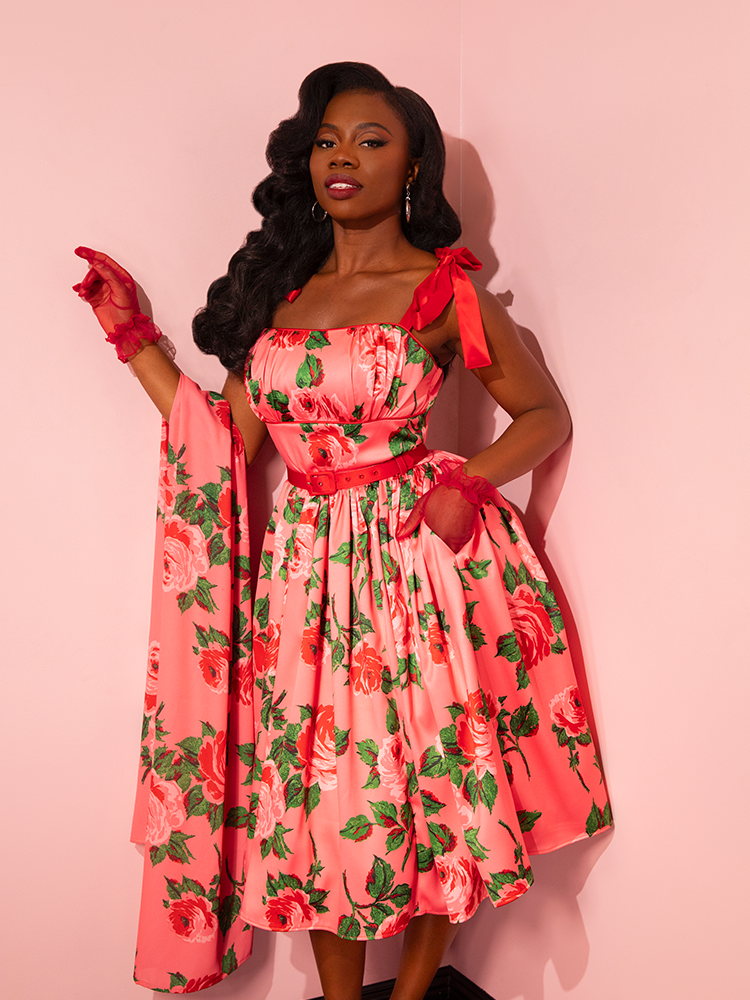 Transport yourself to the golden era of fashion with the 1950s Satin Swing Sundress and Scarf in Pink Vintage Roses from Vixen Clothing. Marvel at the beauty of this retro ensemble as it graces the runway with vintage models.