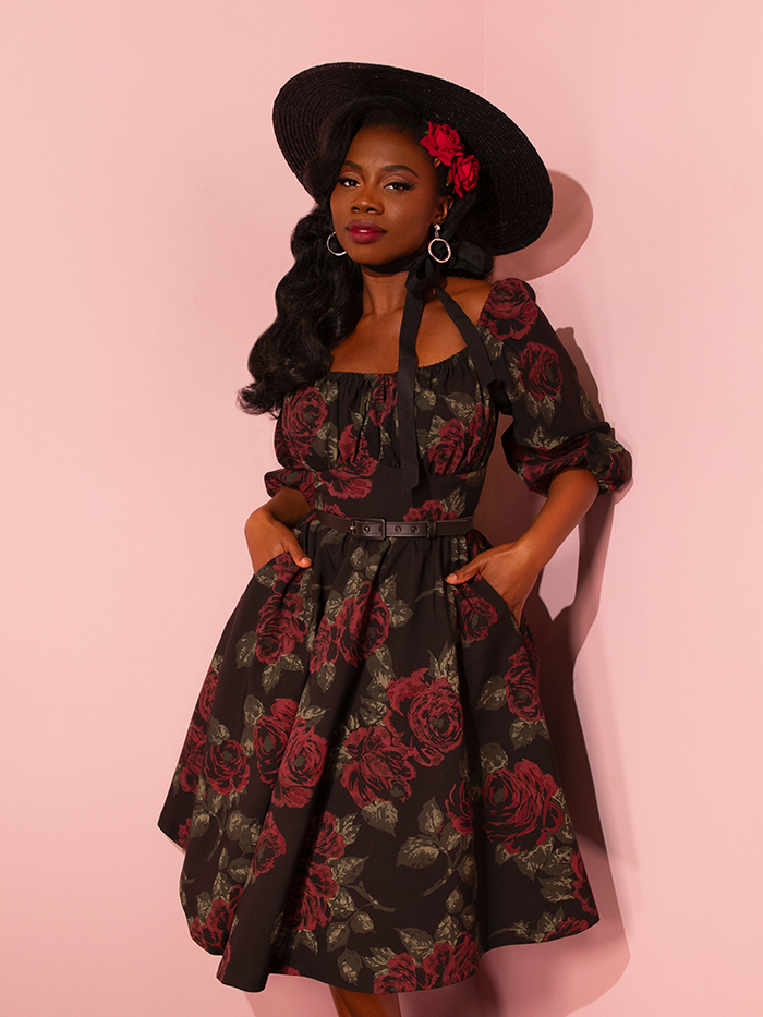 Exuding playfulness and charm, female vintage models strike fun and flirty poses in Vixen Clothing's Vintage Black Roses Vacation Dress, a delightful addition to the brand's collection of retro clothing.