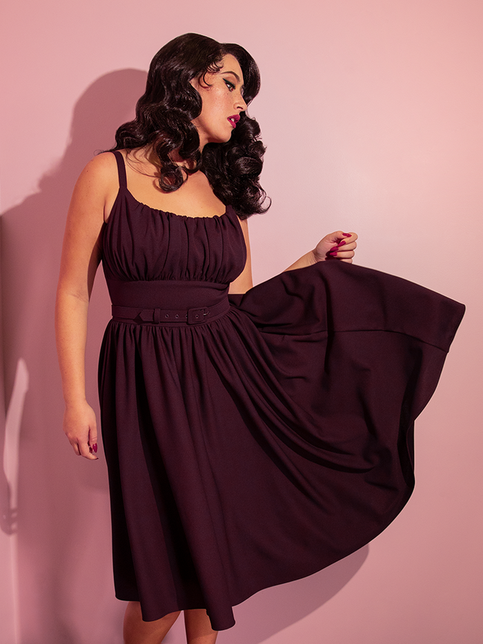 Brittany wears the Ingenue Swing Dress in Eggplant Purple from retro dress company Vixen Clothing.