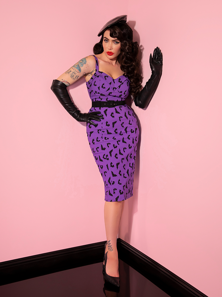 Playfully posing, Micheline Pitt models the Maneater Wiggle Dress in Bat Print from vintage inspired clothing maker Vixen Clothing.