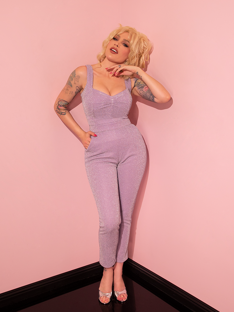 In a captivating fashion, the female model highlights the Lilac Lurex Cigarette Pants from Vixen Clothing, exuding elegance and retro vibes.