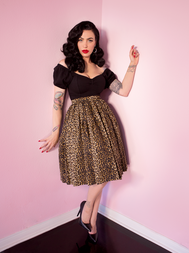 Striking a pose, Micheline Pitt is showing off her retro swing skirt in leopard print along with a black vintage style top.