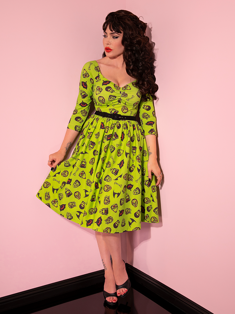 Micheline Pitt pulling out the sides of the skirt on her Wicked Swing Dress in Vintage Monster Mash Print.