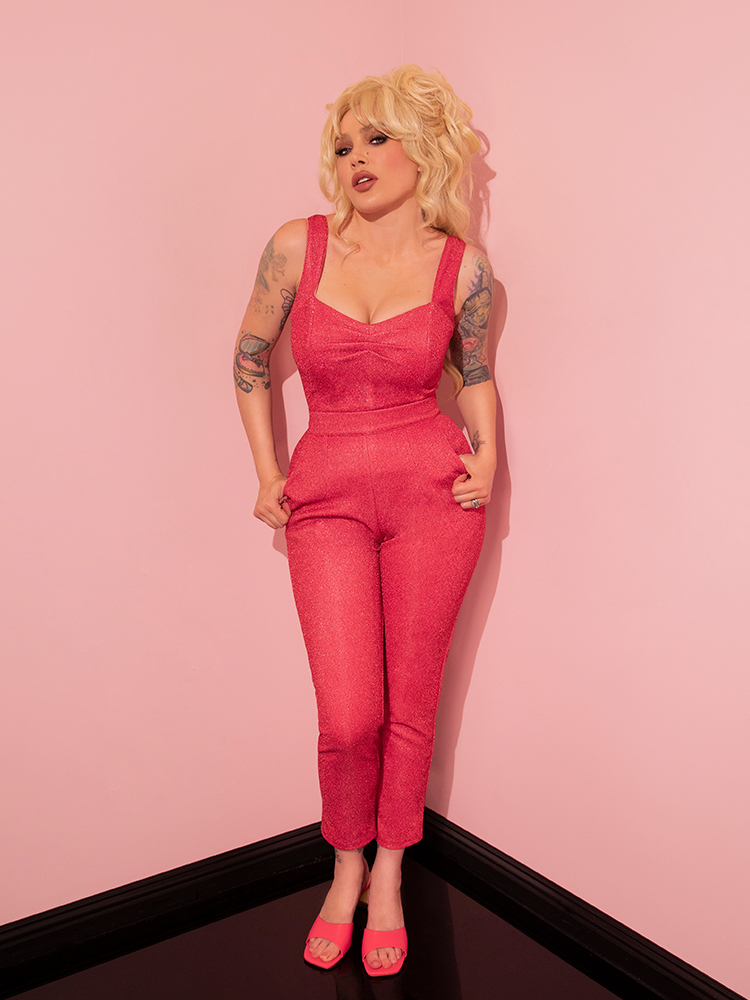 With an enchanting vintage appeal, the retro style model showcases the Cigarette Pants in Candy Pink Lurex from Vixen Clothing, captivating all with her allure.