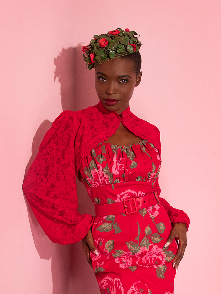 The Vixen Vintage Lace Bolero in Classic Red as worn by Brittany with a rose print vintage style dress and matching headpiece.