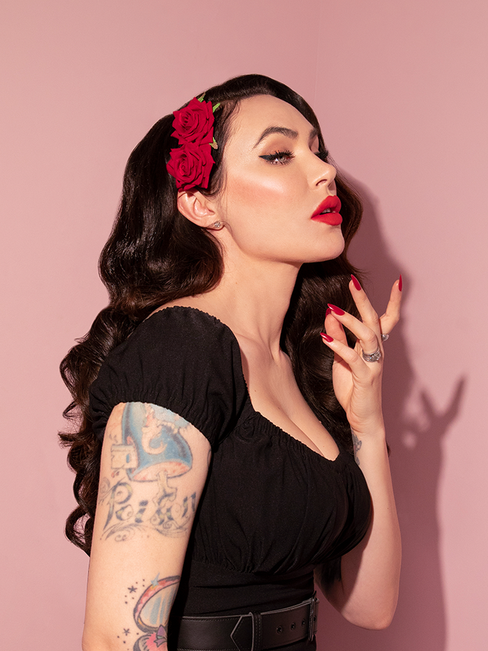 Profile shot of Micheline Pitt modeling the Vintage Double Red Rose Hair Comb made by Vixen Clothing.