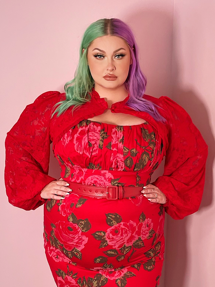 Model with sea-green and purple hair wears the Vixen Vintage Lace Bolero in Classic Red.