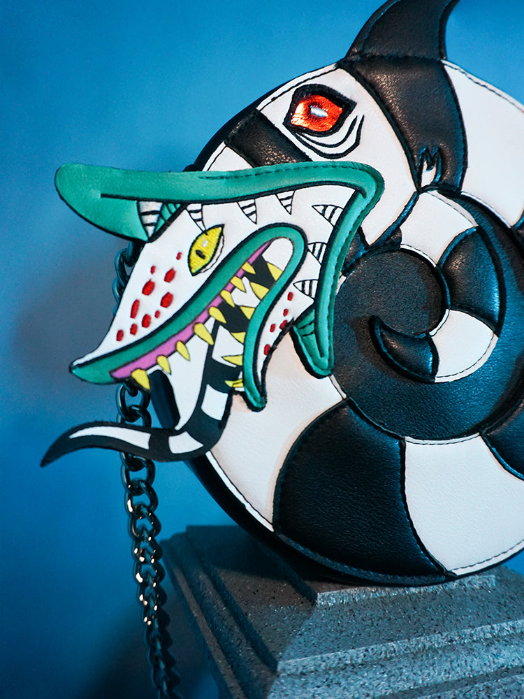 Close-up on the creature face on the BEETLEJUICE™ Sandworm Crossbody Bag from retro clothing company Vixen Clothing.