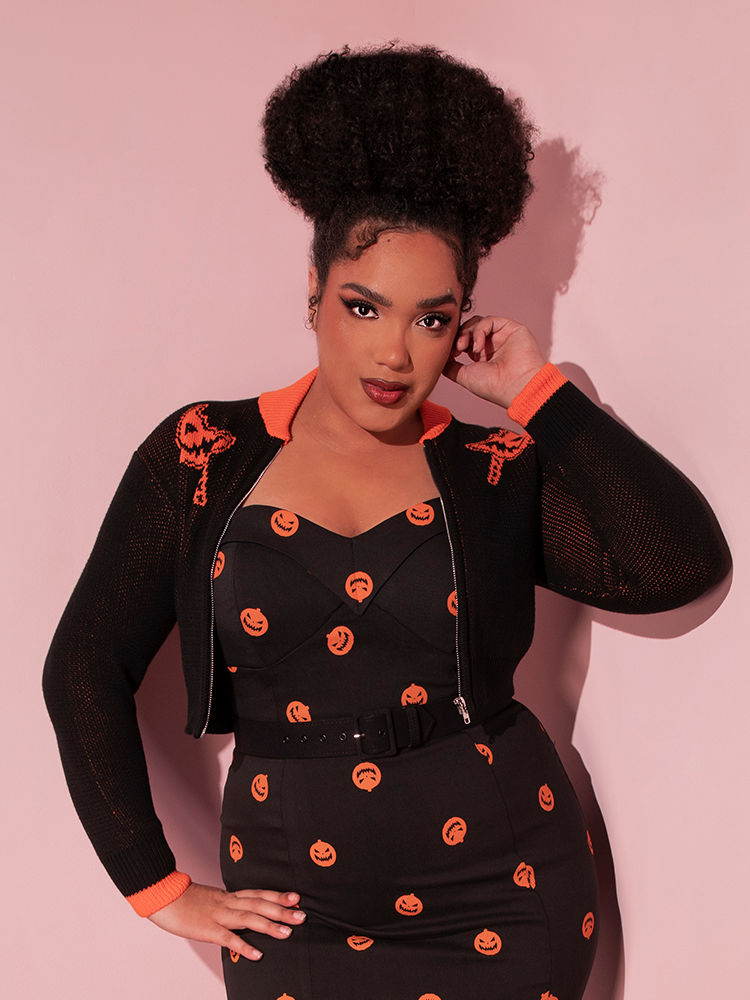 Ashleeta posing in a Halloween inspired outfit including the TRICK R TREAT™ Flaming Pumpkin Cropped Knit Jacket.