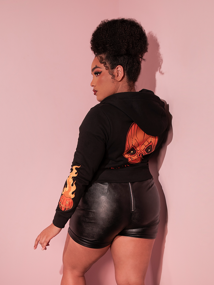 Model facing away from the camera gives a glimpse of the back of the TRICK R TREAT™ Sam Cropped Hoodie.