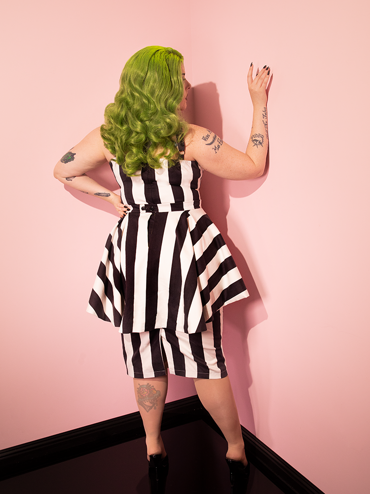 Female model turned away from the camera to show off the back of the BEETLEJUICE™ Ghost with the Most Peplum Dress.