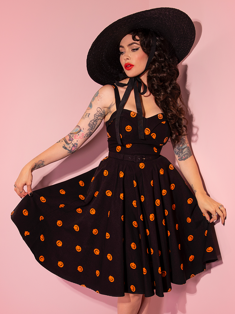 Micheline Pitt posing in the Pumpkin King Maneater Swing Dress in Black from retro style clothing company Vixen Clothing.
