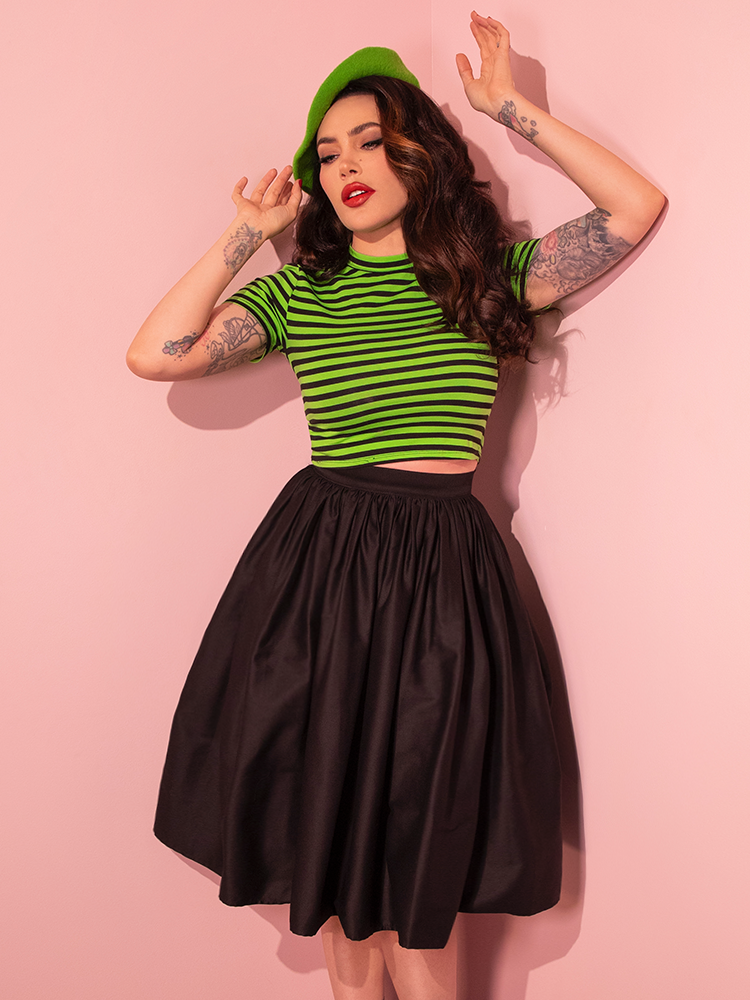 Micheline Pitt showcases the edgy appeal of Vixen Clothing's Bad Girl Crop Top in Slime Green and Black Stripes in a stunning photo shoot.