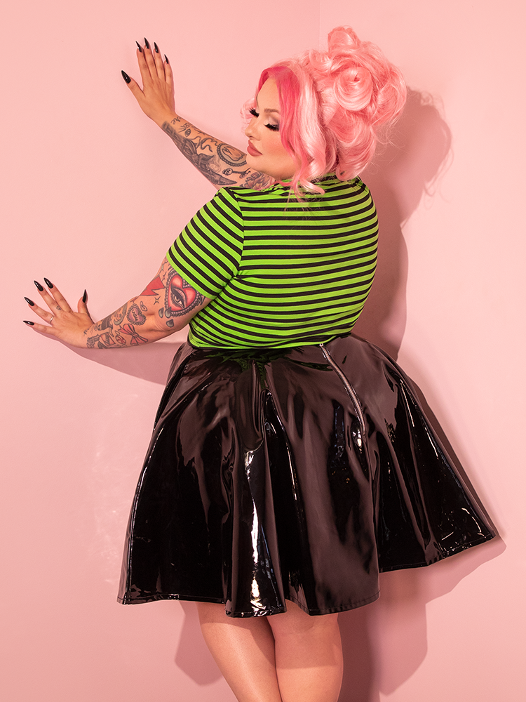The retro allure of Vixen Clothing shines through as a gorgeous female model flaunts the Bad Girl Crop Top in Slime Green and Black Stripes, capturing the essence of the brand's unique aesthetic.