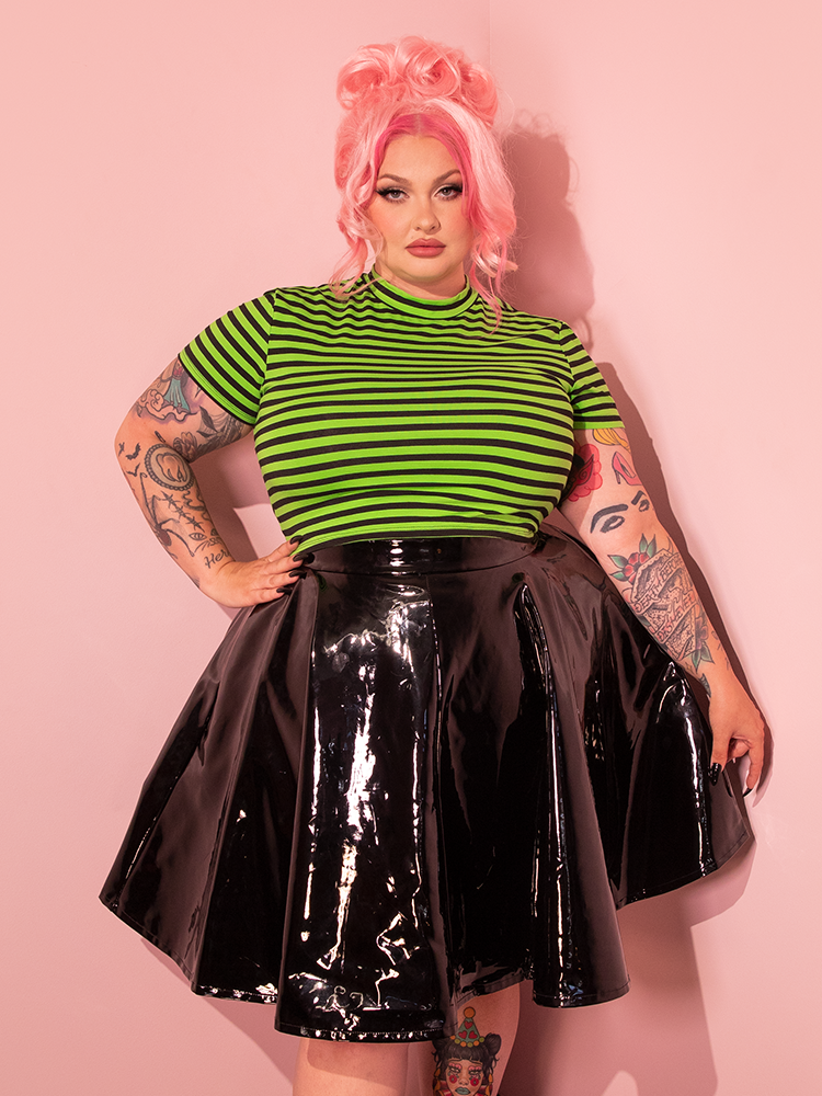 Embracing the energy of the past, female model elegantly models Vixen Clothing's Bad Girl Crop Top in Slime Green and Black Stripes.