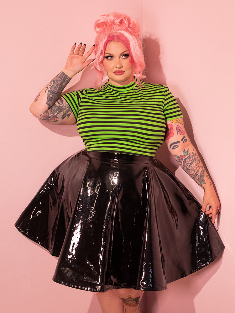 Pink haired female model exudes confidence and style in the Bad Girl Crop Top in Slime Green and Black Stripes, a prime example of Vixen Clothing's retro fashion expertise.