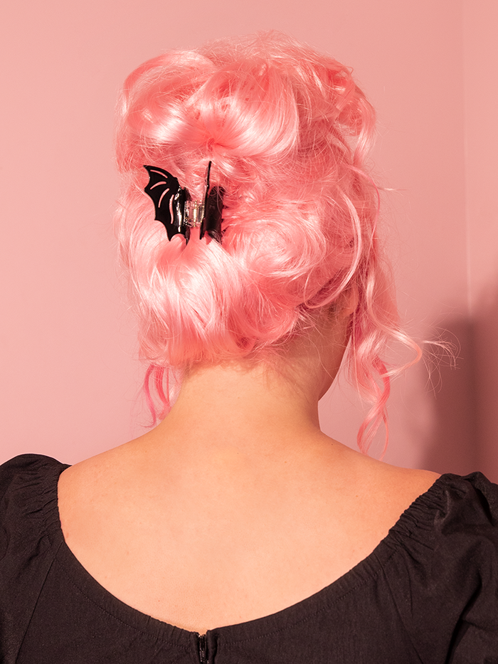 The model strikes a captivating pose with the brand-new Black Bat Claw Hair Clip from Vixen Clothing, the acclaimed retro clothing manufacturer.