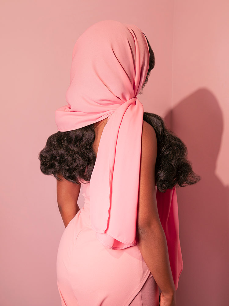 The radiant female mannequin displays the 1950s-inspired chiffon scarf in blush pink from the retro label Vixen Clothing.