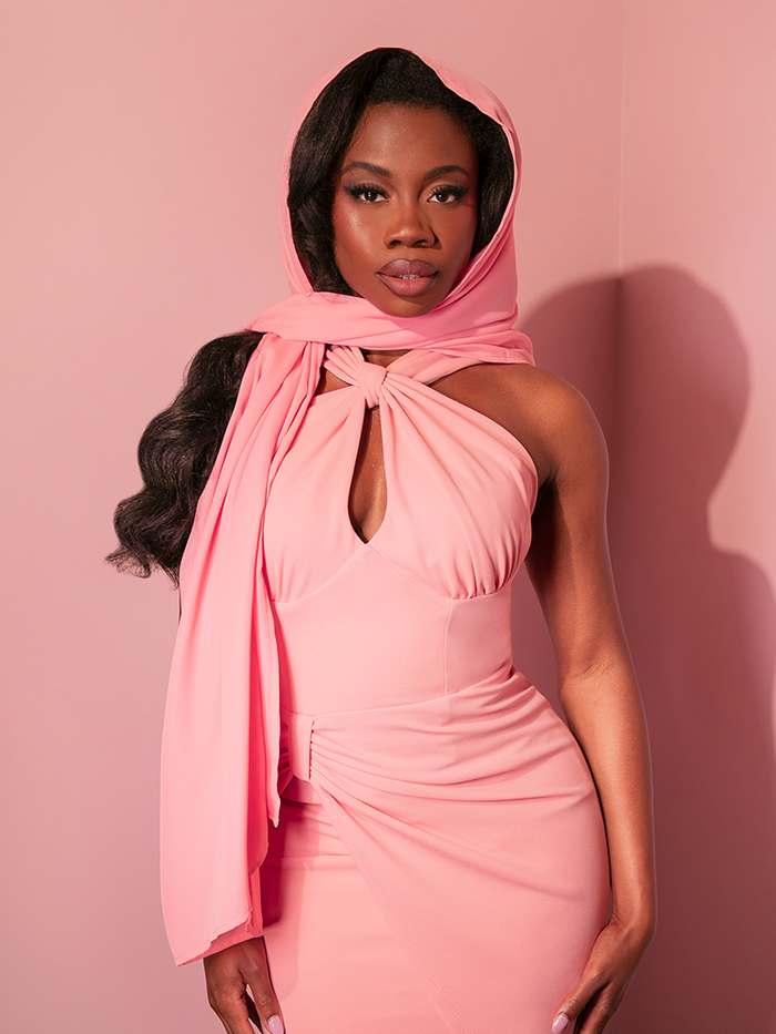 The stunning lady model presents the blush pink chiffon scarf, reminiscent of the 1950s, from retro fashion house Vixen Clothing.