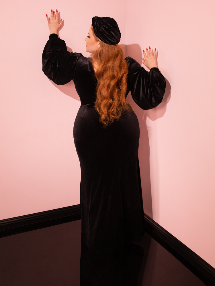 The allure of retro fashion is embodied by the gorgeous model in Vixen Clothing's Film Noir Gown and Turbanette in Black Velvet, a masterpiece of retro clothing design.