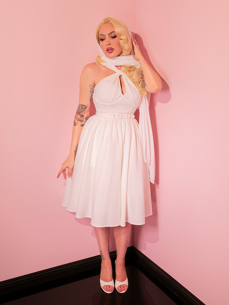 Adorn yourself in the Ivory Golden Era Swing Dress and Chiffon Scarf to embrace the nostalgic allure of retro dresses, each swish and sway taking you back to a more elegant era.