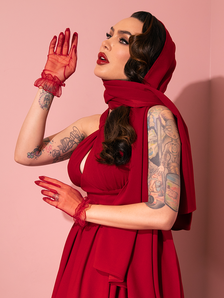 A display of elegance unfolds as retro models showcase the Ruby Red Golden Era Swing Dress and Scarf from Vixen Clothing, capturing the essence of a bygone era.