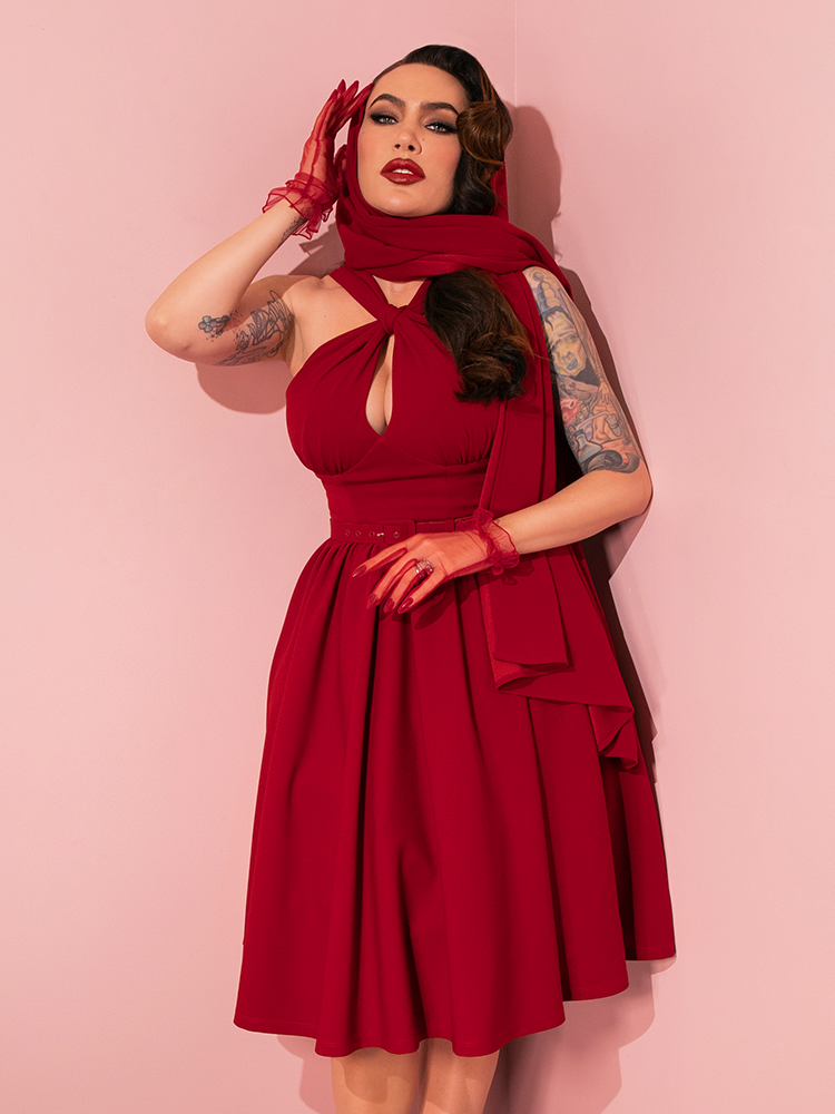 The allure of Vixen Clothing's Golden Era Swing Dress and Scarf in Ruby Red is brought to life through the poised and graceful poses of retro models.