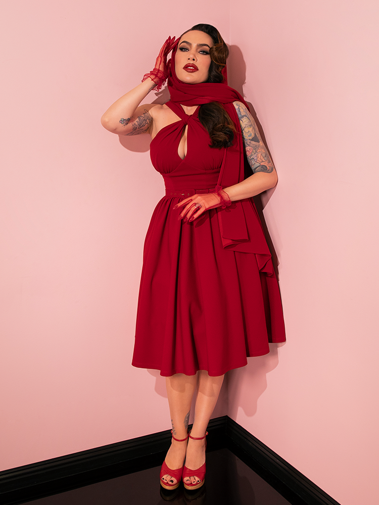 Vintage glamour comes alive as models strike various poses, highlighting the beauty of the Golden Era Swing Dress and Scarf in Ruby Red from Vixen Clothing.