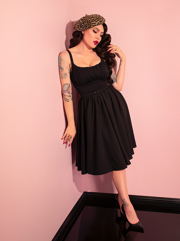 Displaying versatility, Micheline Pitt models the retro-inspired Ingenue Dress in Black from Vixen Clothing, striking various captivating poses.