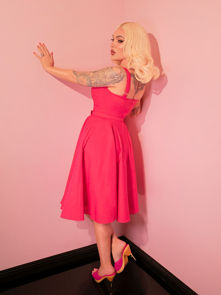 The Jawbreaker Swing Dress, with its vibrant hot pink shade, serves as a perfect canvas for accessorizing with retro-inspired jewelry and footwear, inviting creativity in styling.