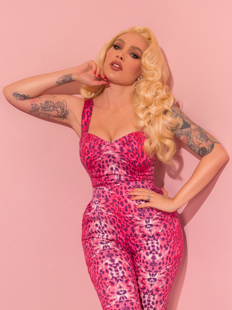 With a touch of retro charm, a lovely female model exudes elegance while wearing the Pink Leopard Print Vamp Top by Vixen Clothing, a beloved brand known for its vintage-inspired designs.