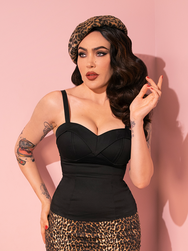 Radiating elegance, Micheline Pitt captivates attention in the retro-inspired Maneater Top in Black from Vixen Clothing, showcasing its allure through various poses.