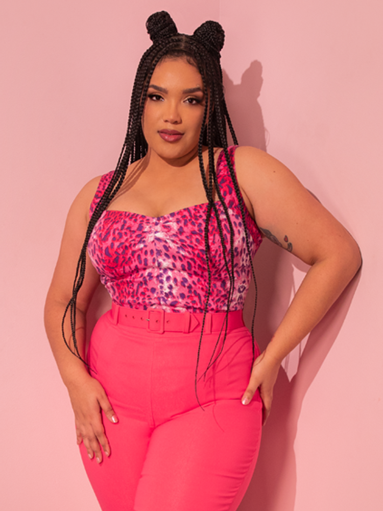 Radiating vintage allure, a stunning female model captivates with her elegant pose while showcasing the Pink Leopard Print Vamp Top from Vixen Clothing, a beloved retro clothing brand.