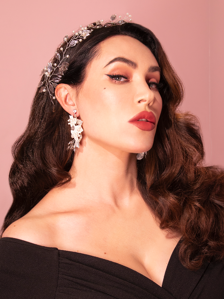 Displaying the elegance of Vixen Clothing, an attractive brunette model playfully showcases the Vintage-Style Leaf and Pearl Hair Wire in Silver, adding a touch of retro sophistication.