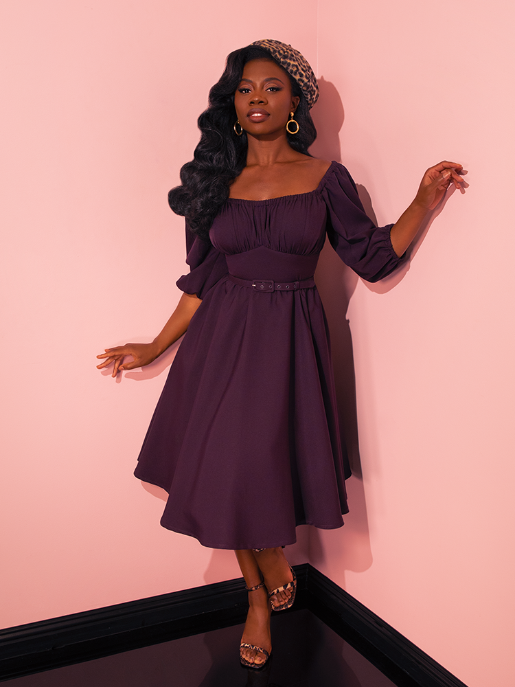 In a display of vivacity and charm, female vintage models showcase the Vacation Dress in Plum from Vixen Clothing, emphasizing the delightful spirit of this retro dress.