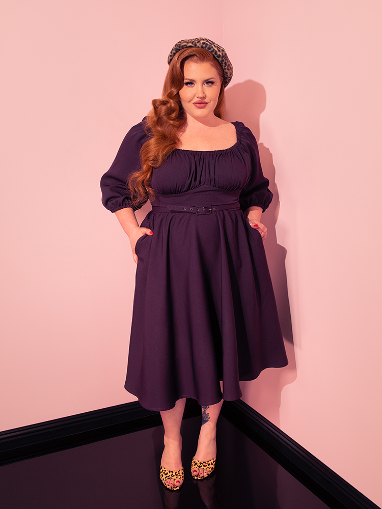 With infectious energy, female vintage models showcase the Vacation Dress in Plum from Vixen Clothing, radiating the brand's commitment to creating fun and flirty retro clothing.