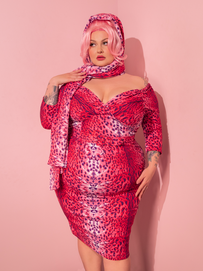 A stunning retro-inspired model showcases the Starlet Wiggle Dress and Scarf in Pink Leopard Print, created by the vintage clothing brand Vixen Clothing.